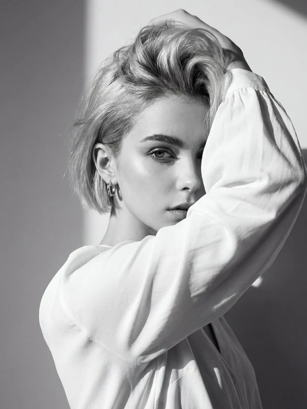 Monochrome portrait of a woman with an arm framing one eye